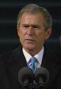 President George Bush pauses for a moment during a press conference to make a serious facial expression.